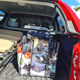 Large black trim clear camping bag packed with shoes and clothing sitting in back of 4WD