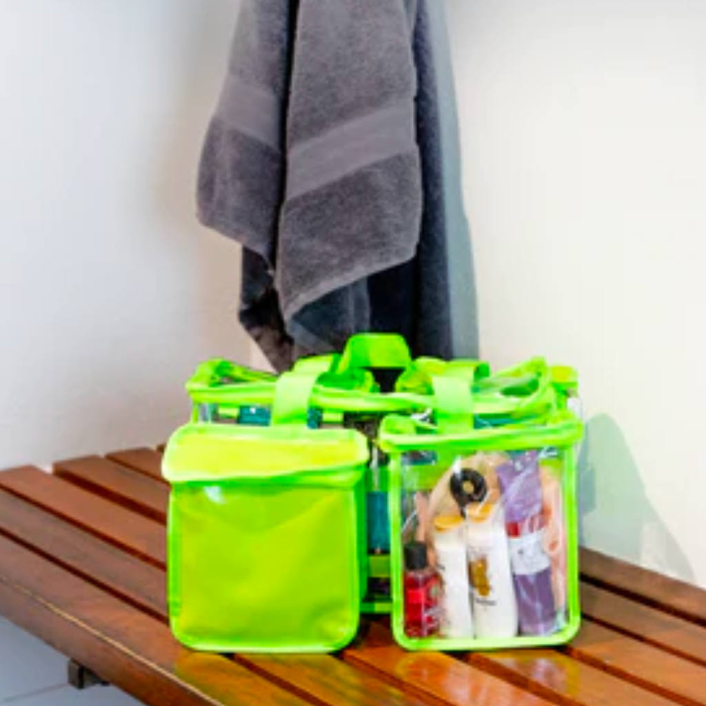 Toiletry items packed into green CamPaq toiletry bag sitting on bathroom bench beside hanging towel