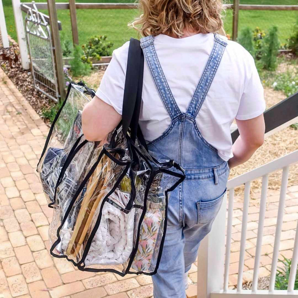 Woman walking along path holding large black CamOaq Bag over her shoulder