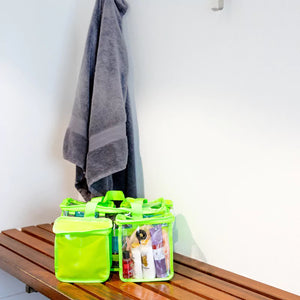 Green clear pvc toiletry bag with privacy pocket sitting on shower amenities bench beside handing towel