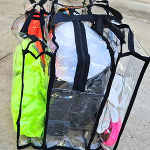 Large black trim clear camping bag filled with hi viz vest and hard hat and work gear sitting on concrete