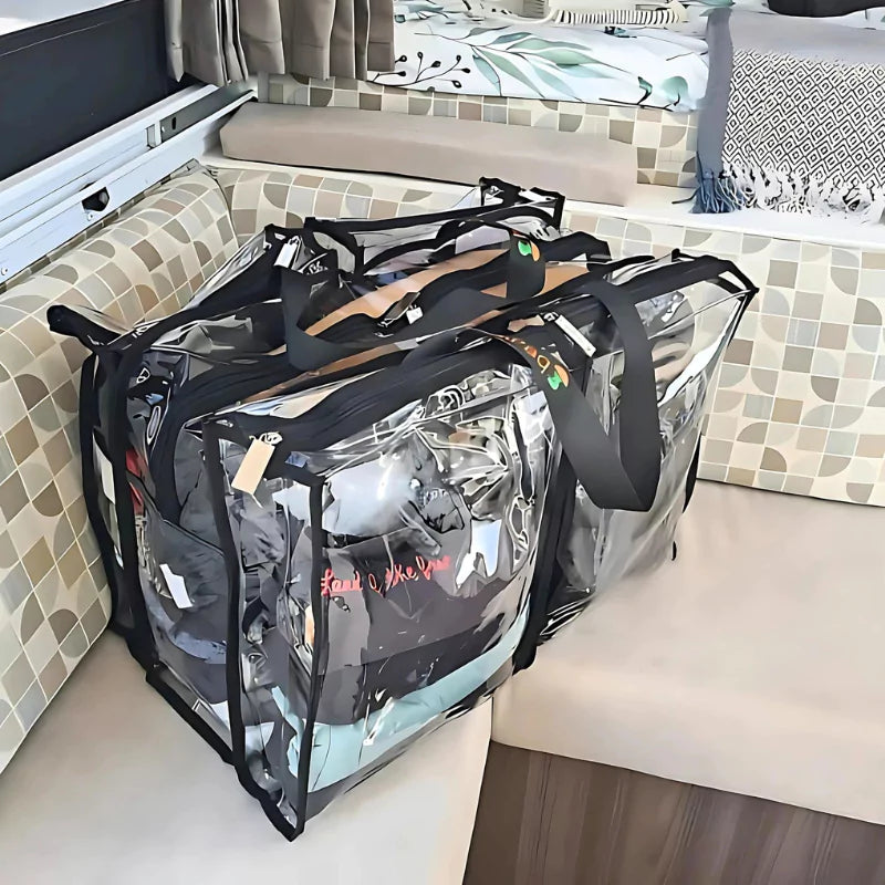 Large black trim clear camping bag with packed with clothes sitting on corner of camper trailer lounge