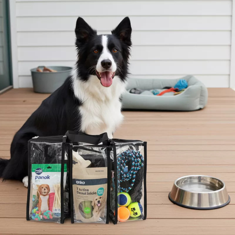 Medium black clear CamPaq camping bag showing front 3 pockets filled with dog treats and toys on wooden deck beside border collie
