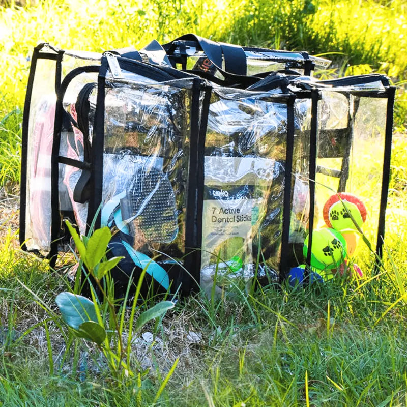 Clear medium black CamPaq camping bag showing front 3 pockets on grass showing pet toys and black handles