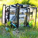 Clear medium black CamPaq camping bag showing front 3 pockets on grass showing pet toys and black handles
