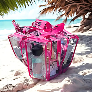 Hot pink clear camping beach bag with on a sandy beach with palm leaves and ocean in the background
