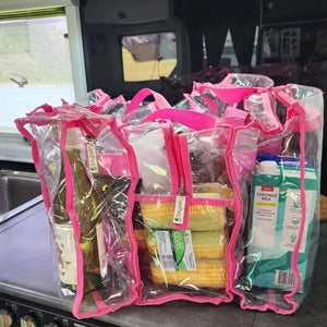 Medium hot pink clear camping bag on caravan kitchen bench filled with food and wine