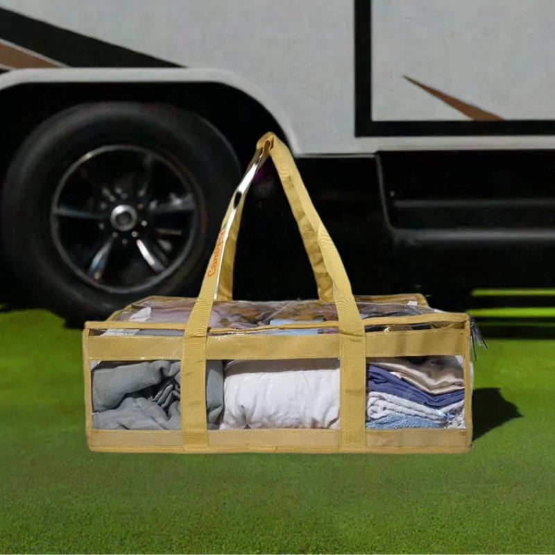 Sand clear under bed storage bag packed with linen on grass beside caravan
