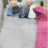 Video of large purple clear CamPaq camping bag being packed on bed with clothes